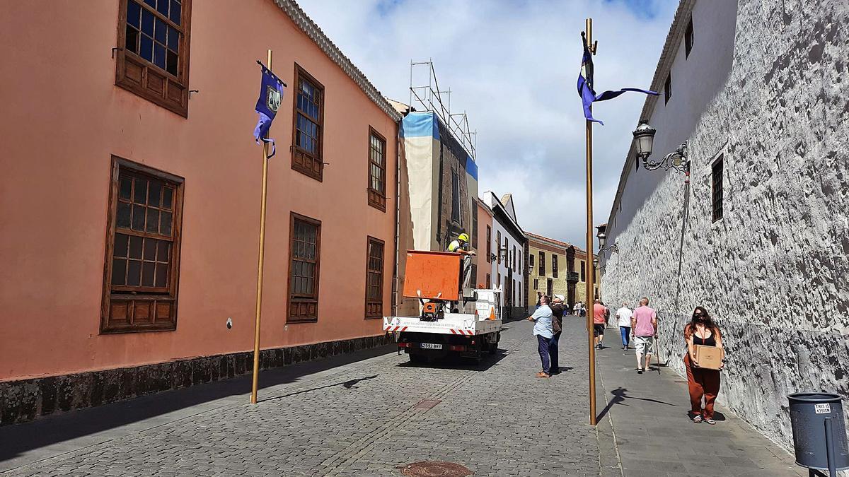 Un momento de las labores que se realizaban en la céntrica calle de La Carrera, con la instalación de unas colgaduras sostenidas en unos postes.