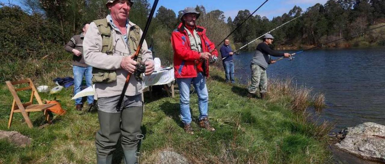 Un grupo de pescadores lanzan sus cañas en el embalse de Zamáns. // R. Grobas