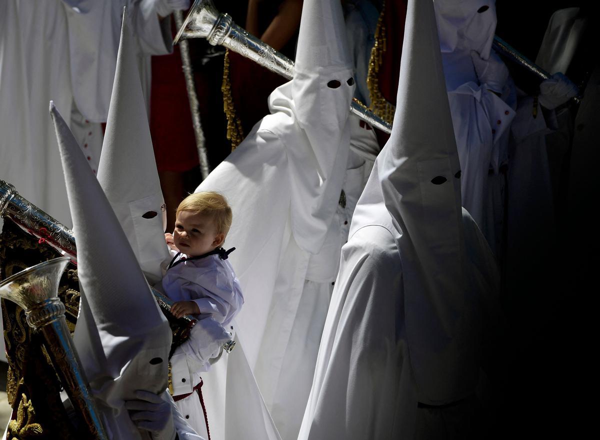 Penitentes de la hermandad de La Paz participan en la procesión del Domingo de Ramos en Sevilla