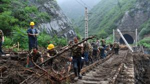 Trabajadores ferroviarios fueron registrados este lunes, 1 de agosto, al retirar árboles caídos sobre las vías del tren, tras el paso del tifón Doksuri, en la aldea de Shuiyuzui, en el distrito de Mentougou (Pekín, China)