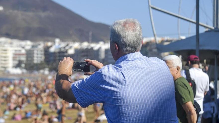 Un jubilado de vacaciones saca una foto en la playa de Las Canteras. | | JUAN CARLOS CASTRO