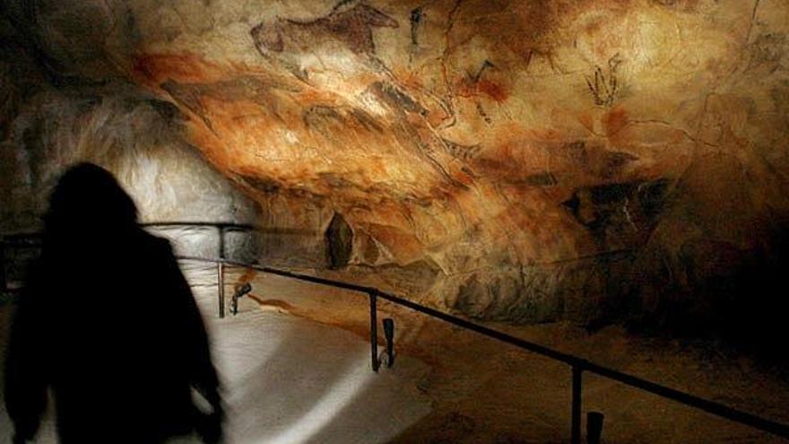 Un visitante pasa ante una reproduccion de la Cueva de Tito Bustillo de Ribadesella