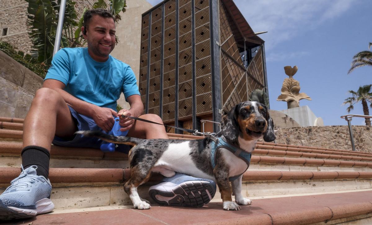 Un joven de Las Palmas de Gran Canaria, con su mascota, junto al auditorio Alfredo Kraus