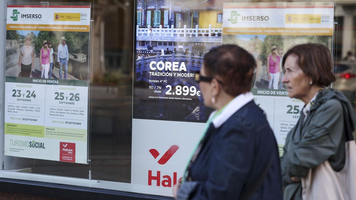 Dos mujeres pasan delante de una agencia de viajes que oferta el programa del Imserso.