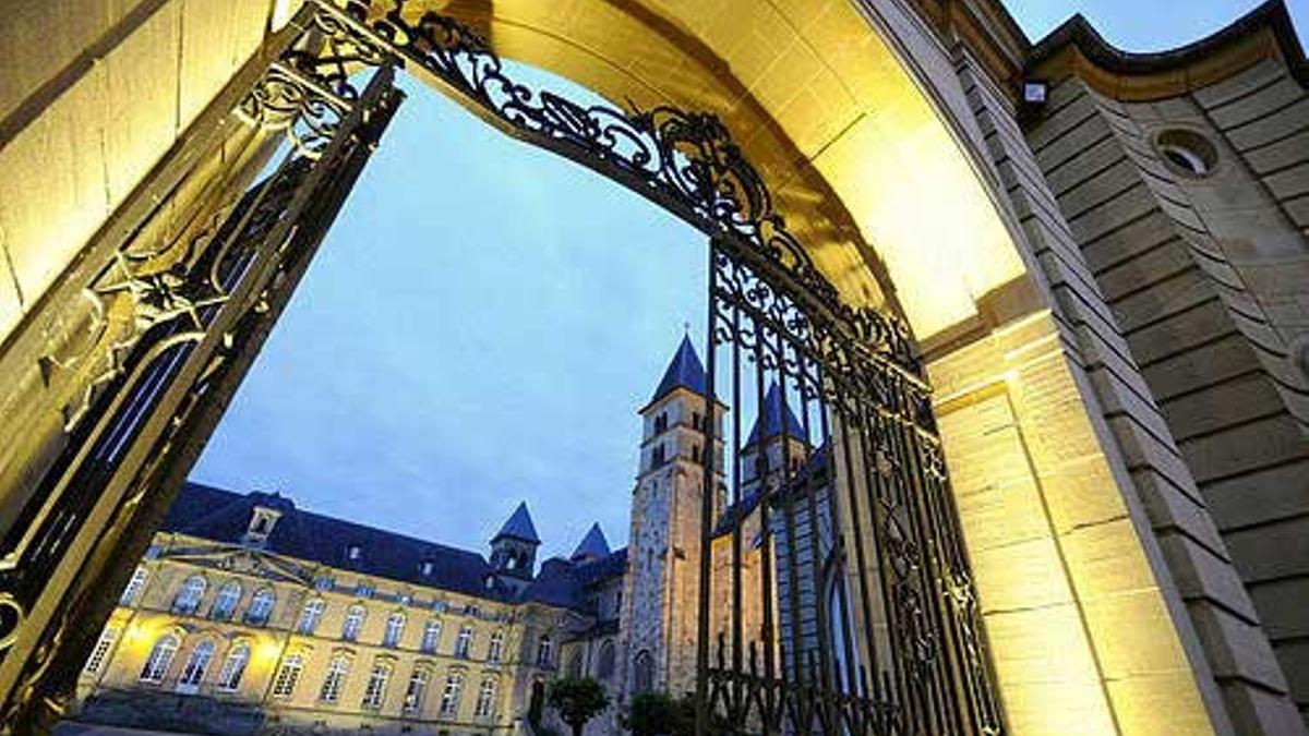 Puerta exterior iluminada de la Basílica de Echternach al atardecer.