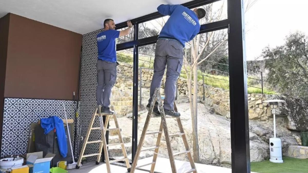 Unos operarios trabajan en el cambio de ventanas en una casa.