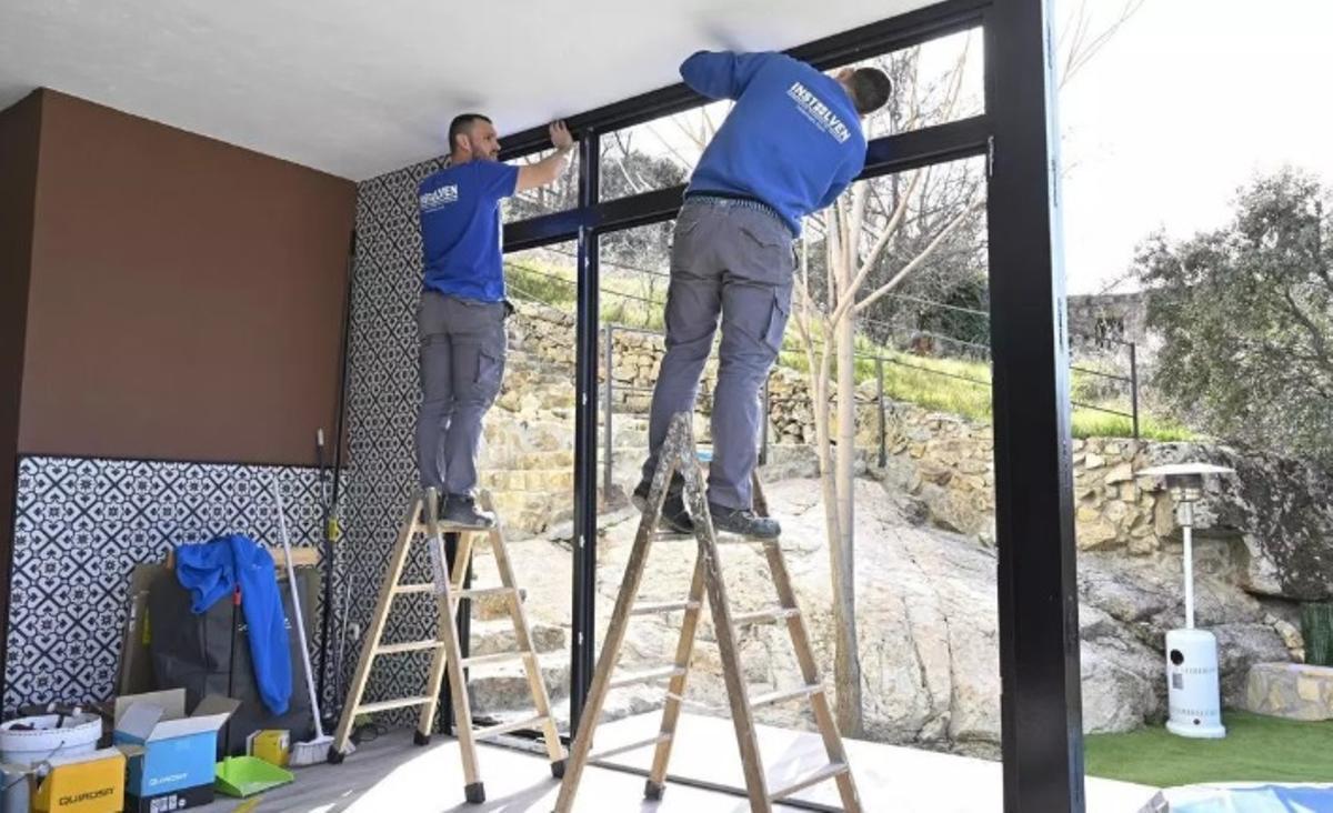 Unos operarios trabajan en el cambio de ventanas en una casa.