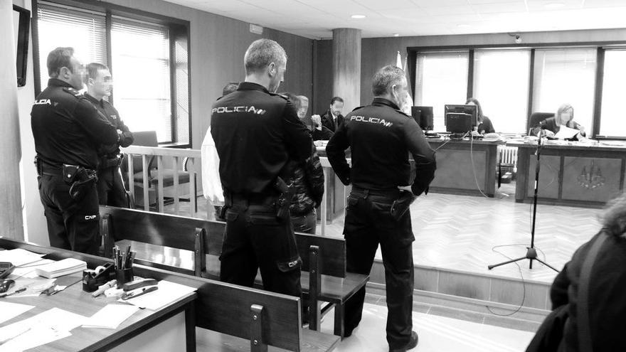 Cuatro policías custodian a la violenta pareja de atracadores en el banquillo de acusados de la sala de Penal 2. // Alba Villar