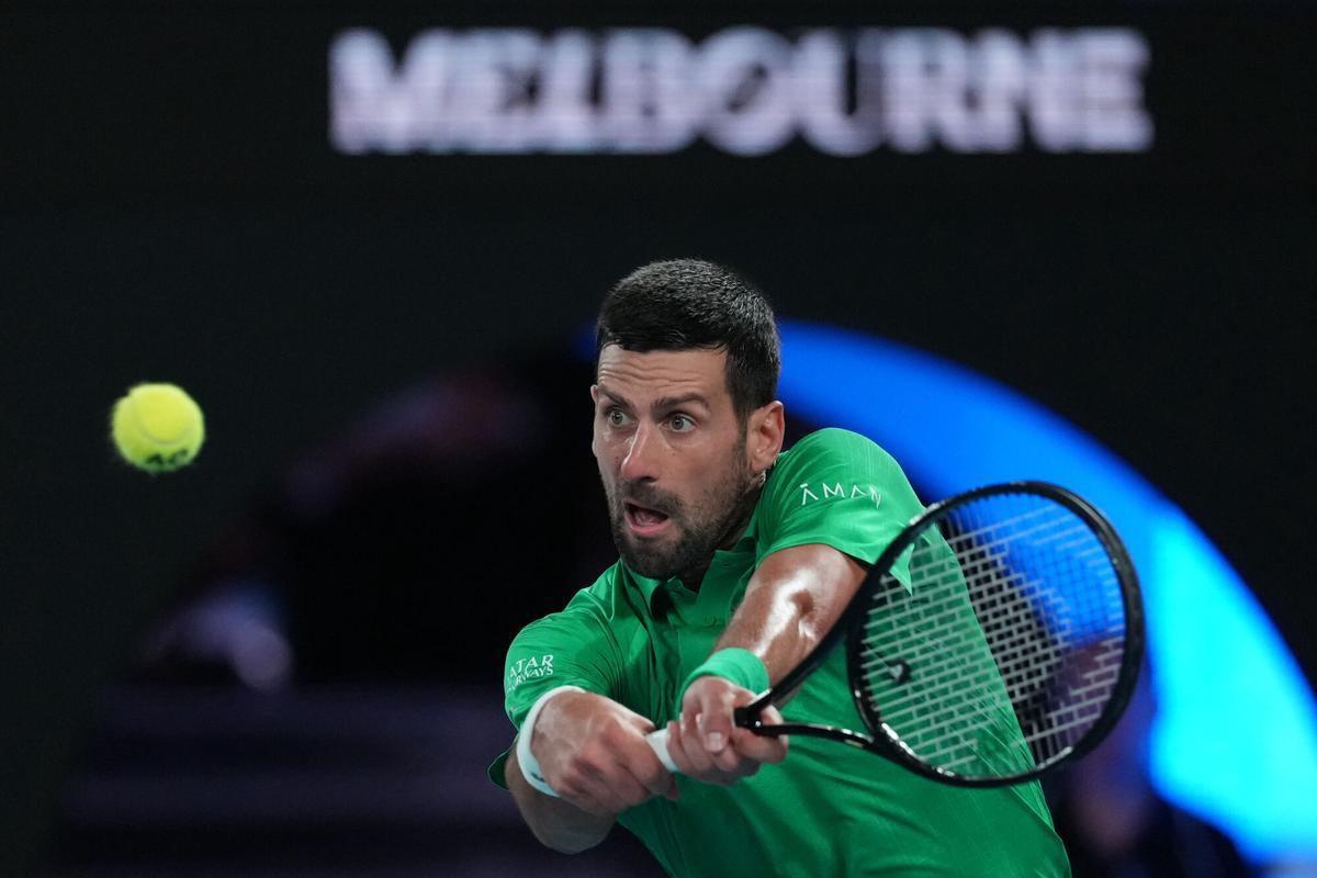 Novak Djokovic of Serbia plays a backhand return to Jannik Sinner of Italy during their semifinal match at the Australian Open tennis championship in Melbourne, Australia, Friday, Jan. 30, 2026. (AP Photo/Asanka Brendon Ratnayake)