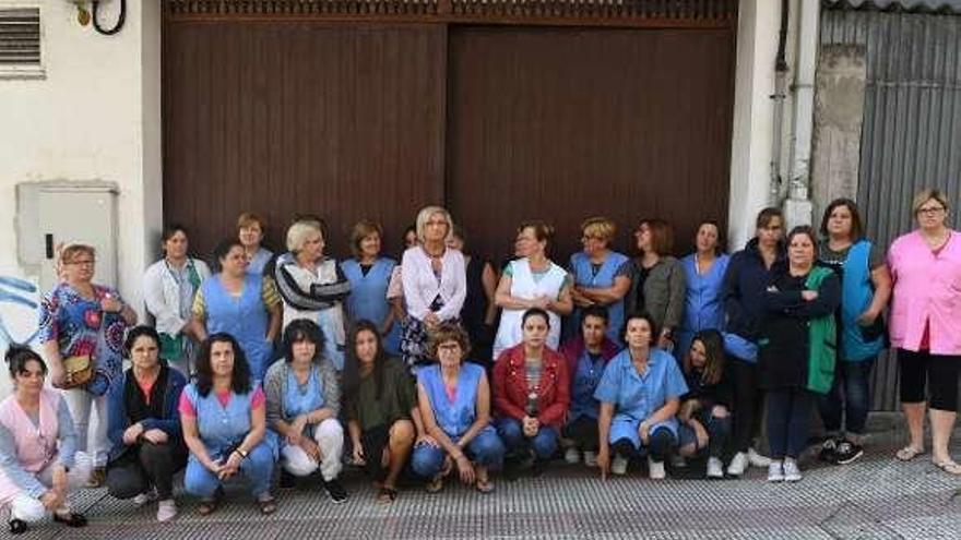 Trabajadoras de Marisa-Arteixo SL, ante la entrada al taller.