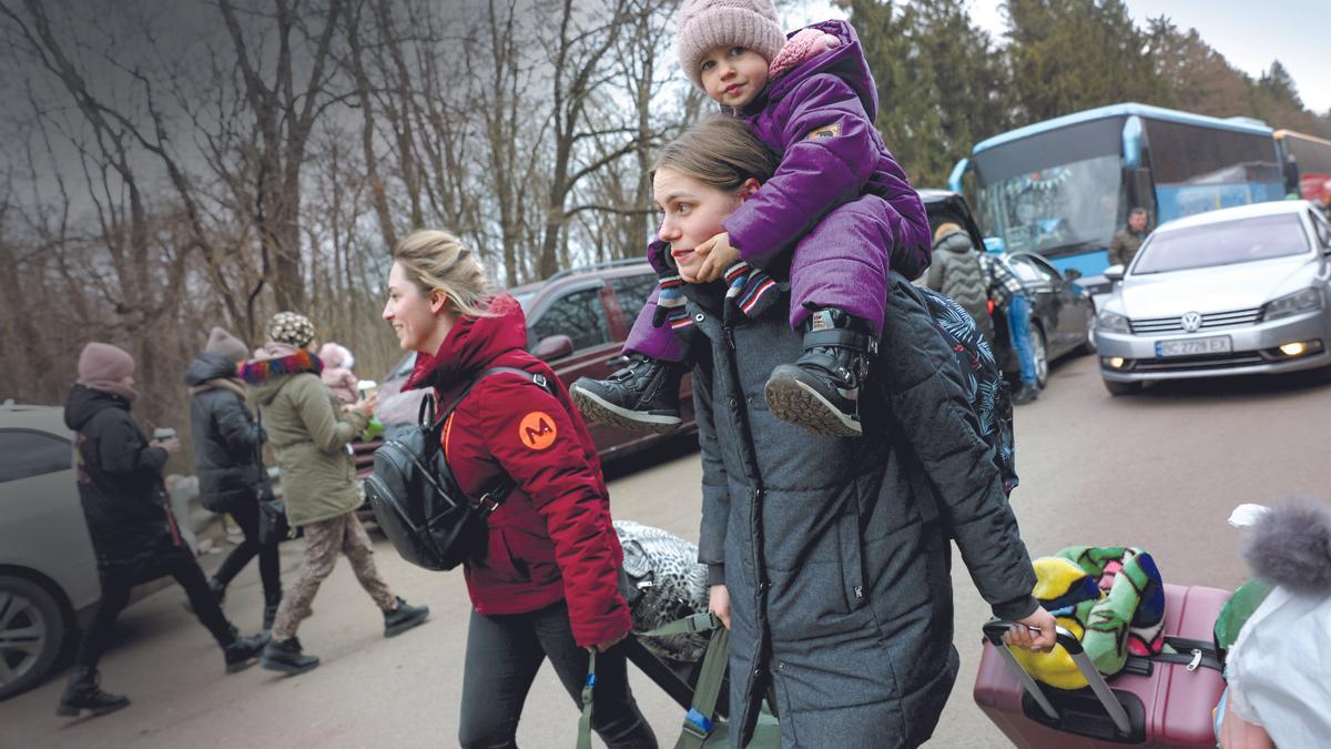 Mujeres y niños ucranianos cruzan la frontera con Polonia.