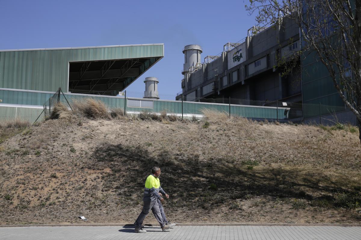 Un operario camina junto a las instalaciones de la incineradora de residuos Tersa, en Sant Adrià de Besòs.