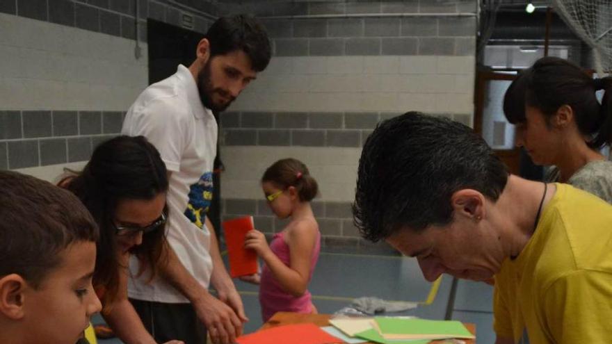 A la izquierda, Pablo López, Isabel Suárez, Dan Miravalles, Tania Cofiño, Tamara Hevia y Mari Paz Martínez confeccionando candelas. A la derecha, Pelayo Roza, quinto por la izquierda, junto a su familia y miembros del gobierno local.