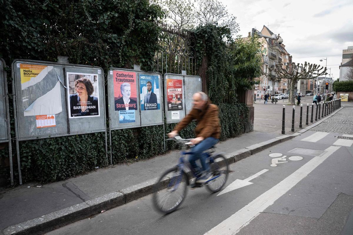 Un ciclista pasa junto a carteles electorales con los candidatos de los comicios de este domingo, el pasado martes en una calle de Estrasburgo.