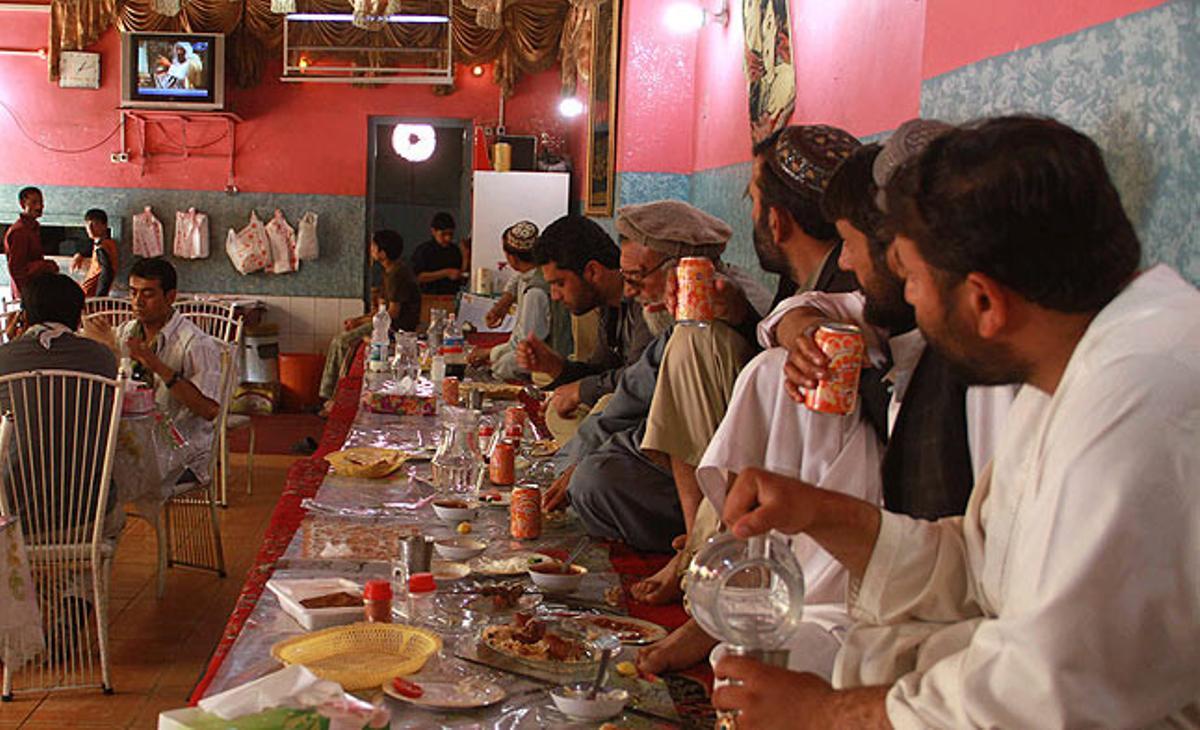 Un grupo de hombres afganos observan atentos la televisión para seguir la noticia de la muerte del líder de Al Qaeda. Herat, Afganistán.
