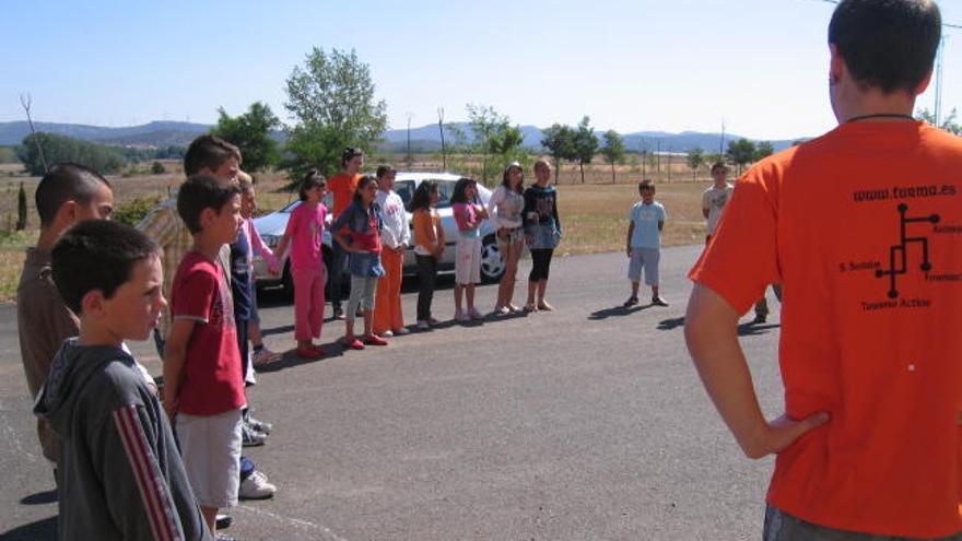 Un grupo de niños colocados en círculo atiende las explicaciones de los monitores,  ayer en Santibáñez