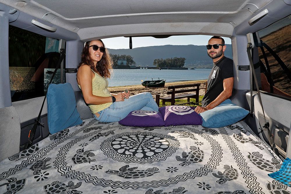 Carlos Cadilla y Lucía Pérez en su furgoneta camper en la playa de Cesantes