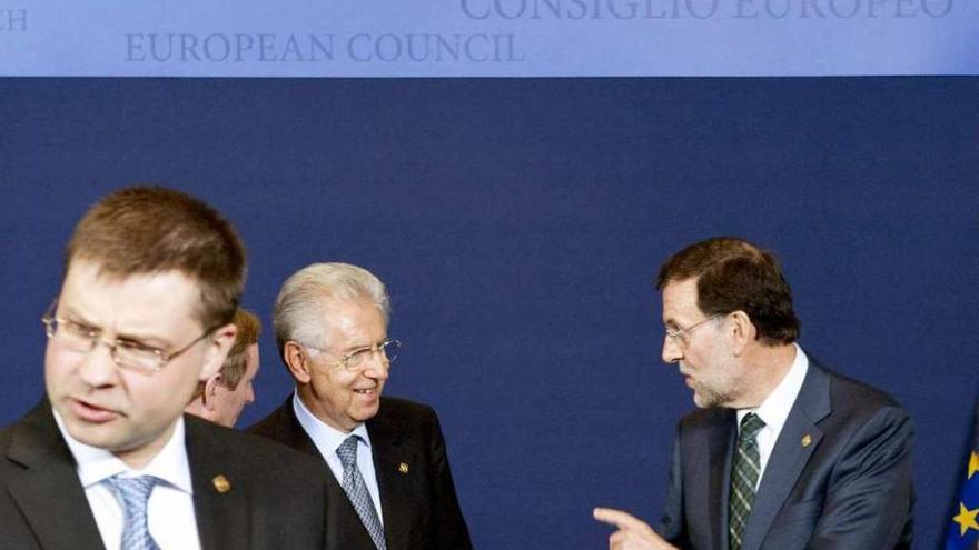 Valdis Dombrovskis, en primer plano, en una imagen de 2012, en la que Rajoy saluda al exprimer ministro de Italia .