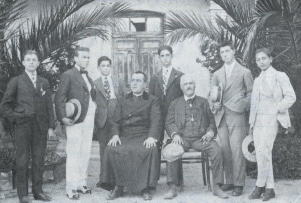 Grupo de jóvenes encinenses alumnos de don Ceferino Sandoval con el alcalde pedáneo Pedro Más en el huerto de la Fonda. Fotografía datada en 1919.