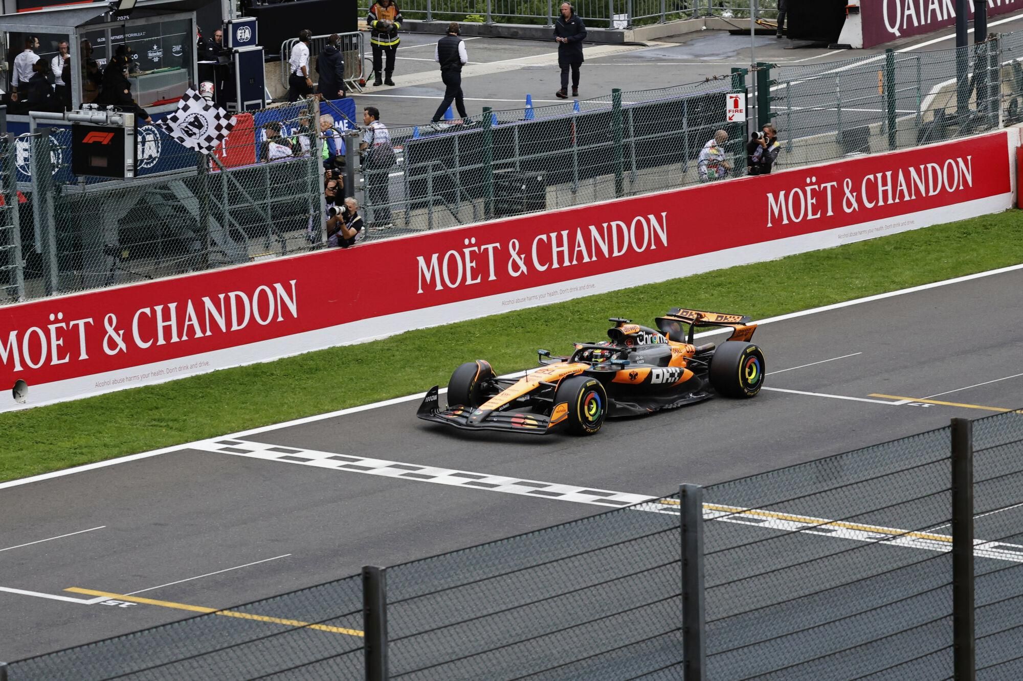 The checkered flag is waved as McLaren driver Oscar Piastri of Australia crosses the finish line to win the Formula One Grand Prix at the Spa-Francorchamps racetrack in Spa, Belgium, Sunday, July 27, 2025. (AP Photo/Geert Vanden Wijngaert)