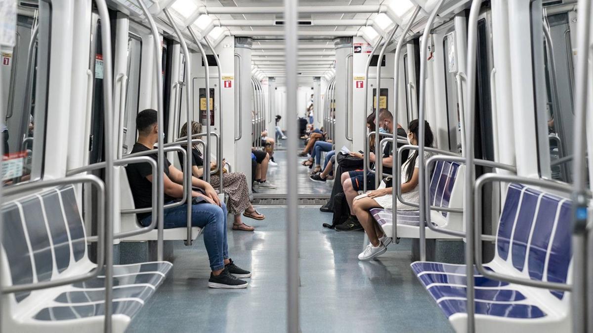 Personas con mascarillas en el metro.