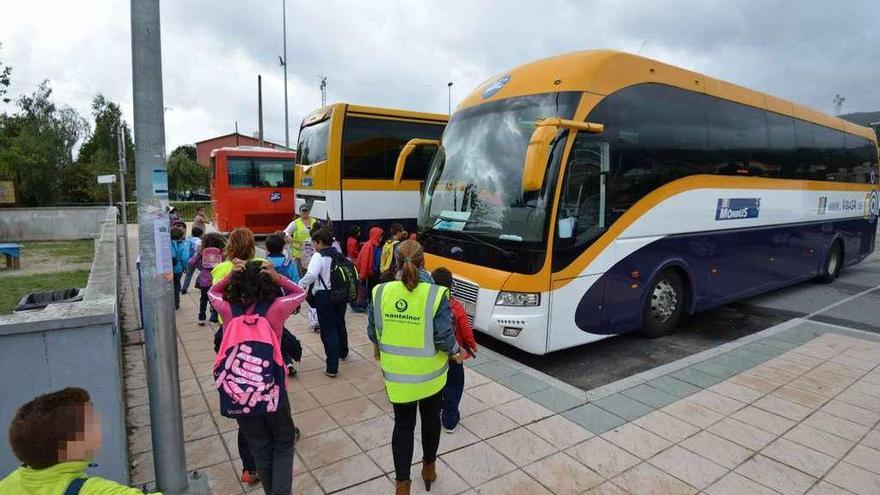 Varios estudiantes suben a un autobús escolar.