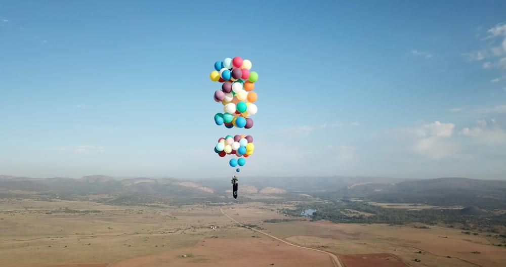 Un hombre vuela en una silla con grandes globos de fiesta atados a ella cerca de Johannesburgo, Sudáfrica.