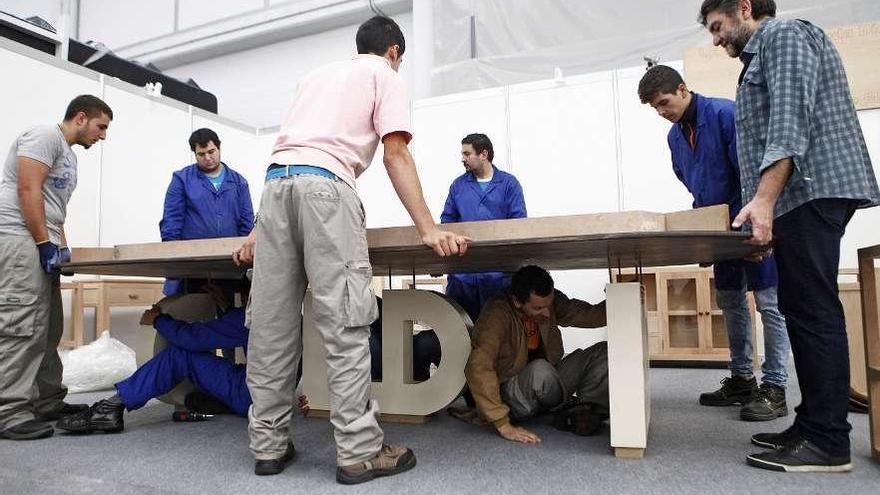 Alumnos montando un espacio expositivo en una Feira do Moble de Galicia. // Bernabé/Luismy