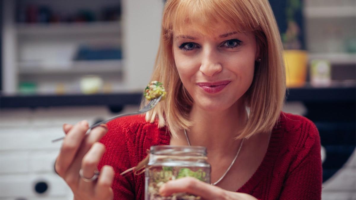 Chica comiendo una ensalada de frasco