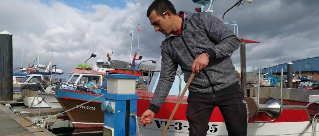 Un marinero de Bueu utiliza ya nuevamente el servicio de agua en el pantalán pesquero. |   // SANTOS ÁLVAREZ