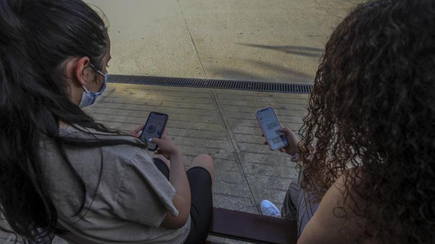 Dos jóvenes conectadas a las redes sociales a través de sus teléfonos. | ANTONIO AMORÓS