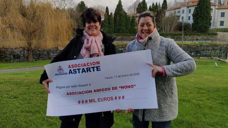 Marta Fernández y Gloria García, de Muros de Nalón, con el cheque donado a la Asociación Amigos de &quot;Nono&quot;.