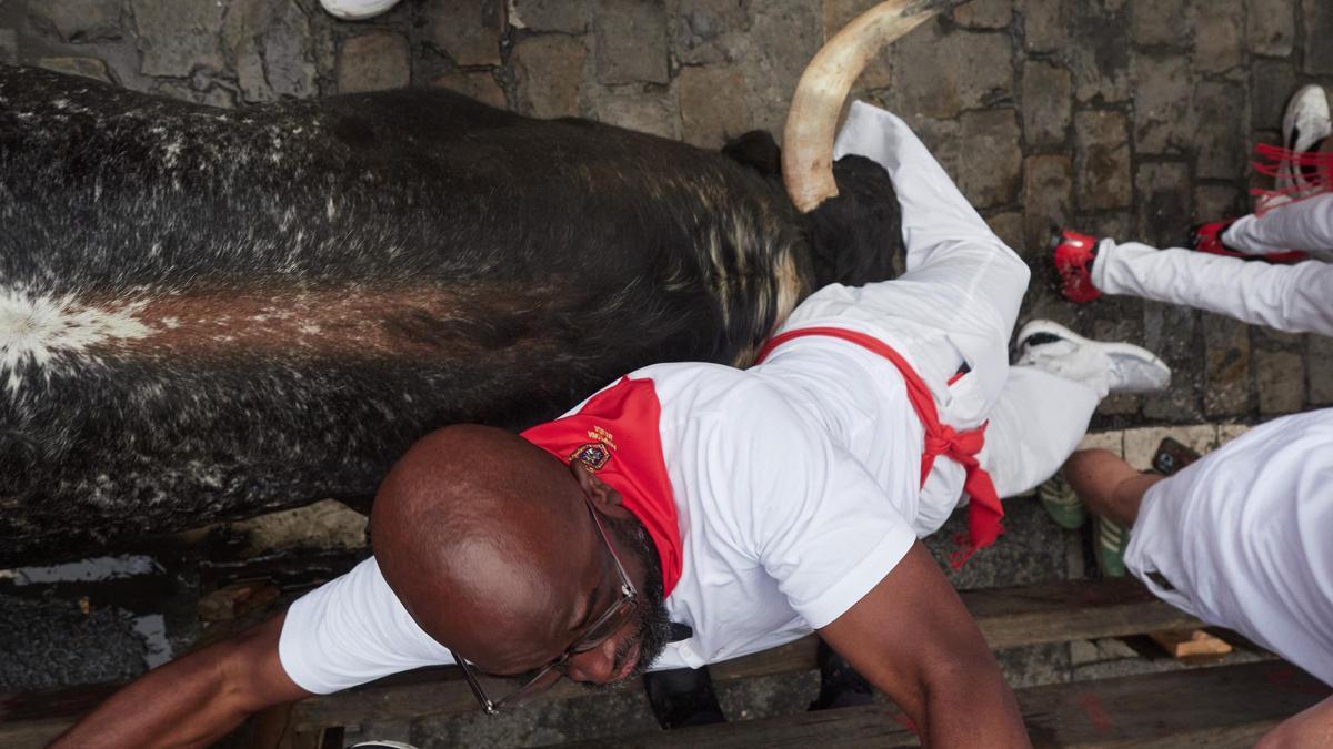 Un toro arrolla a un corredor en un momento del encierro.