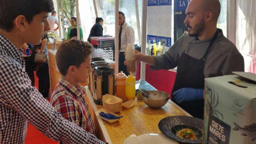 Uno de los cocineros del restaurante Meloxeira explica a dos niños cómo preparar el ceviche. // Muñiz