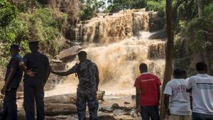 Policías y voluntarios frente a la cascada en la que un árbol mató a 18 personas. 