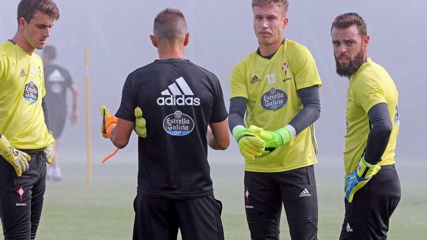 El entrenador de porteros, Nando Villa, de espaldas, charla con Iván, Rubén y Sergio en un reciente entrenamiento en A Madroa. // Marta G. Brea