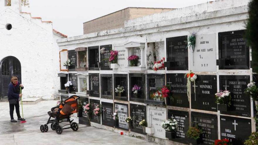 Una mujer limpia el cementerio de Ceares.