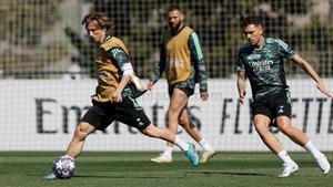 Modric controla la pelota ante Ceballos, observados por Benzema