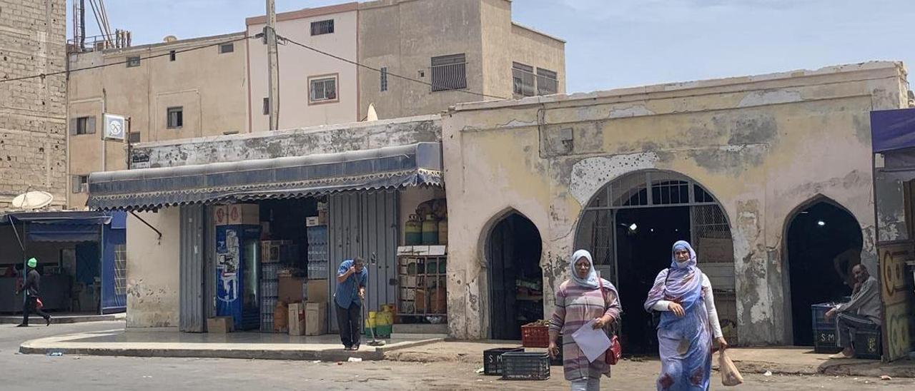 Dos mujeres pasean junto a un mercado de construcción española por las calles de Dajla.