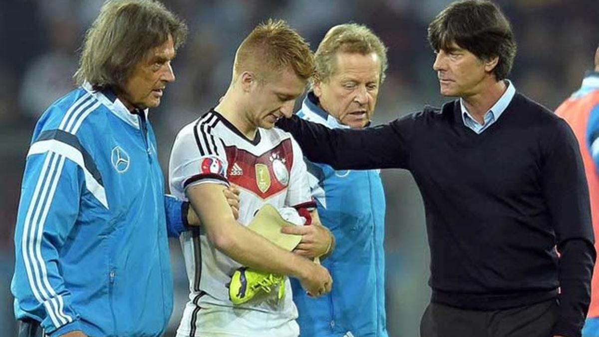 Marco Reus es consolado por el seleccionador alemán Joachim Low tras lesionarse