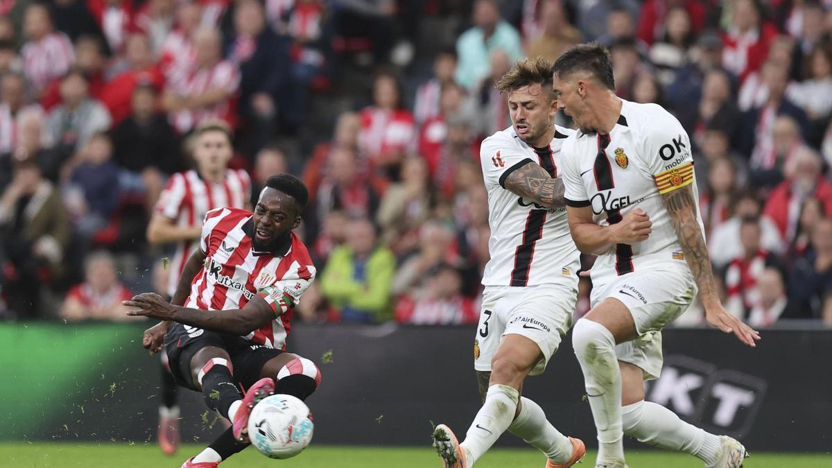 Iñaki Williams dispara con la derecha, mientras está presionado por Raíllo y Maffeo.