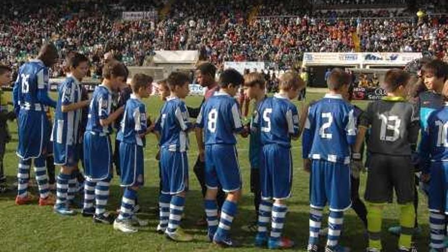 Los jugadores del Barça y Espanyol se saludan con las gradas repletas.