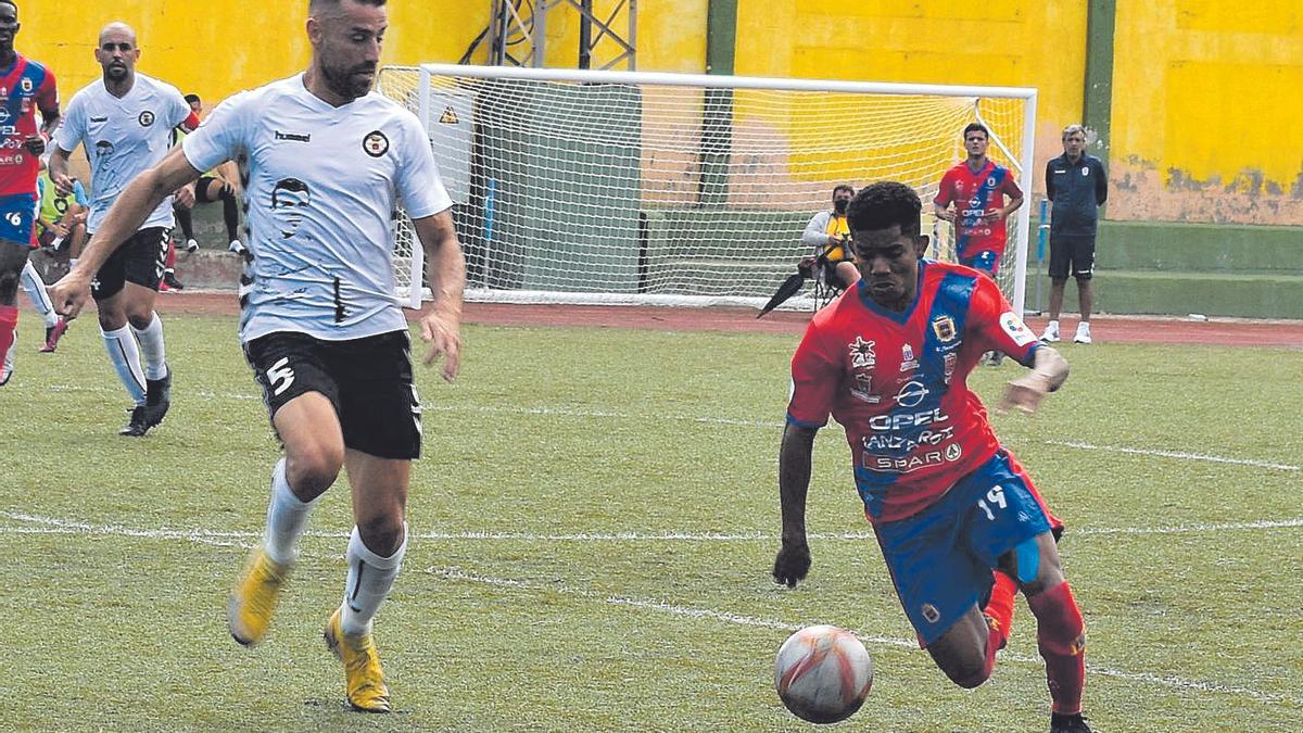 David García -izquierda-, del Arucas, intenta cortar el avance de Alyson, del Lanzarote, en el choque de ayer.
