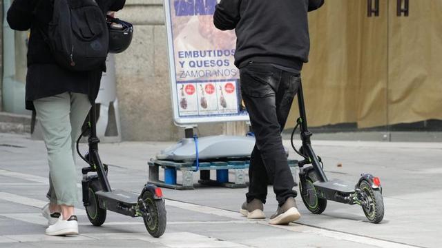 Dos adolescentes circulan por una calle peatonal de la ciudad.