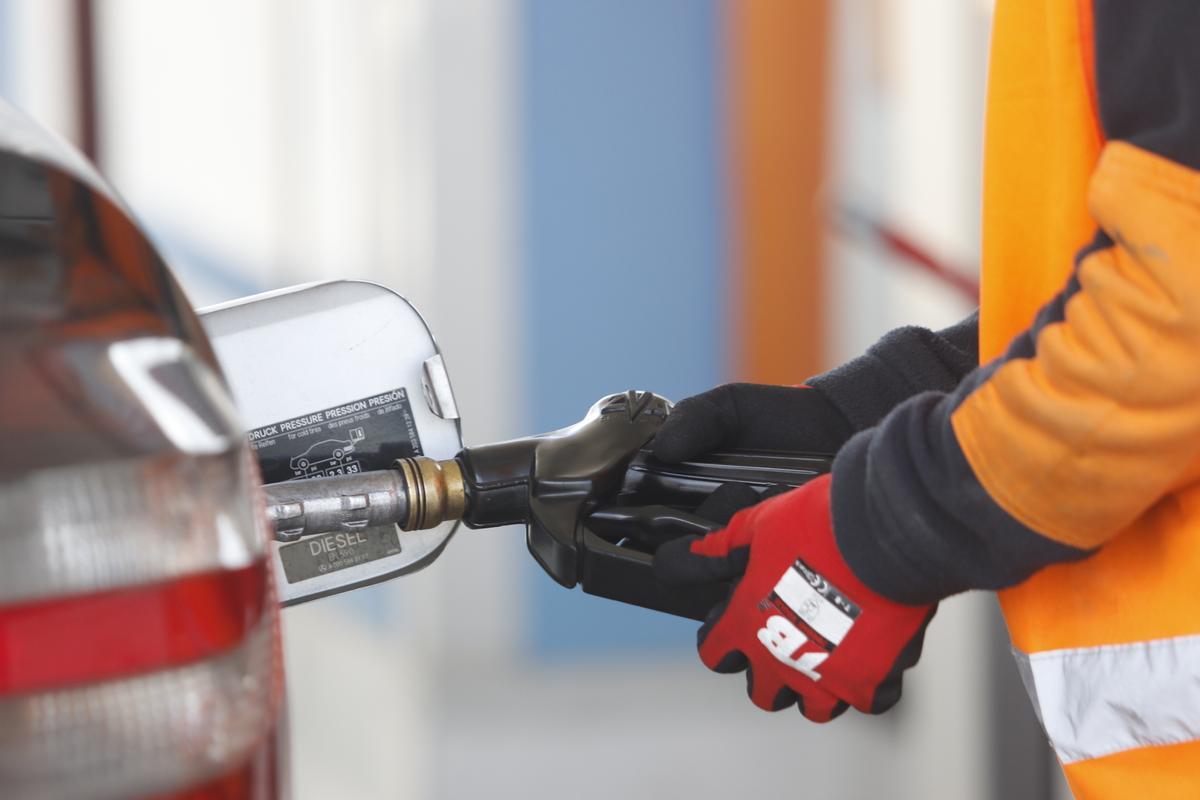 Un operario echando gasolina en un coche.