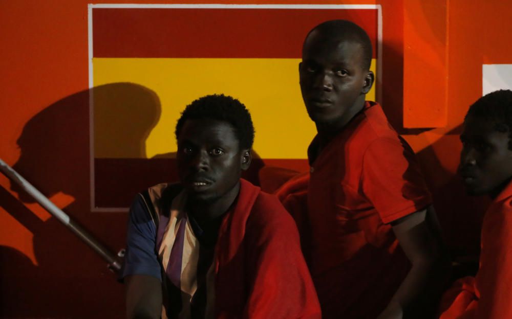 Migrants wait to disembark from a rescue boat at ...