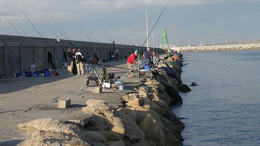 Un grupo de pescadores con sus cañas extendidas en la zona próxima al faro del muelle de Levante, en una imagen de archivo