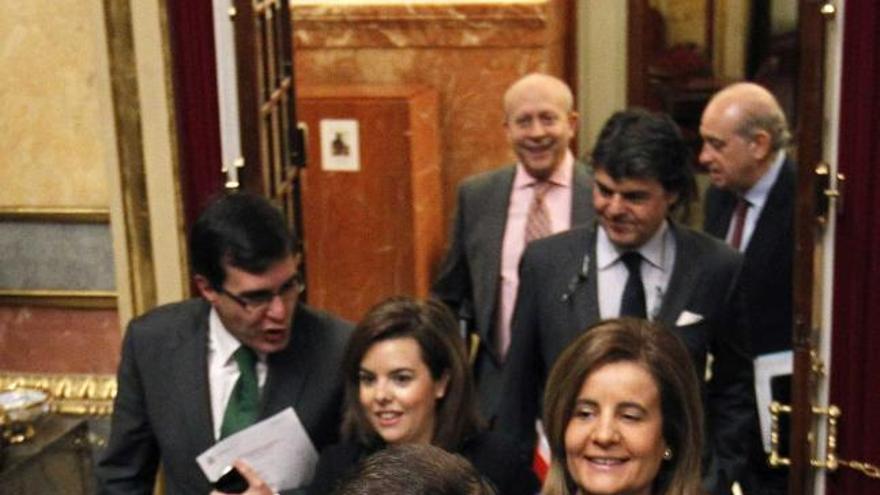 Rajoy, seguido por Báñez y otros miembros del Gobierno, ayer, en el Congreso.