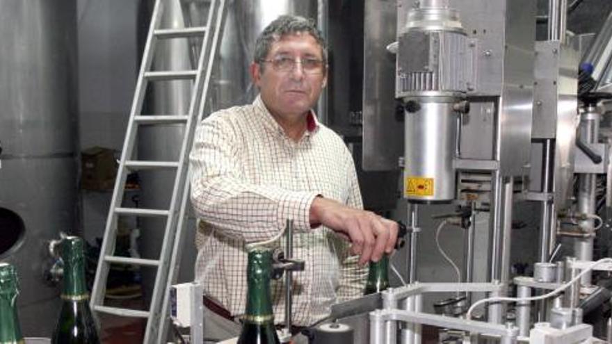 Manuel Martínez, junto a una máquina de producción y algunas botellas de espumoso.