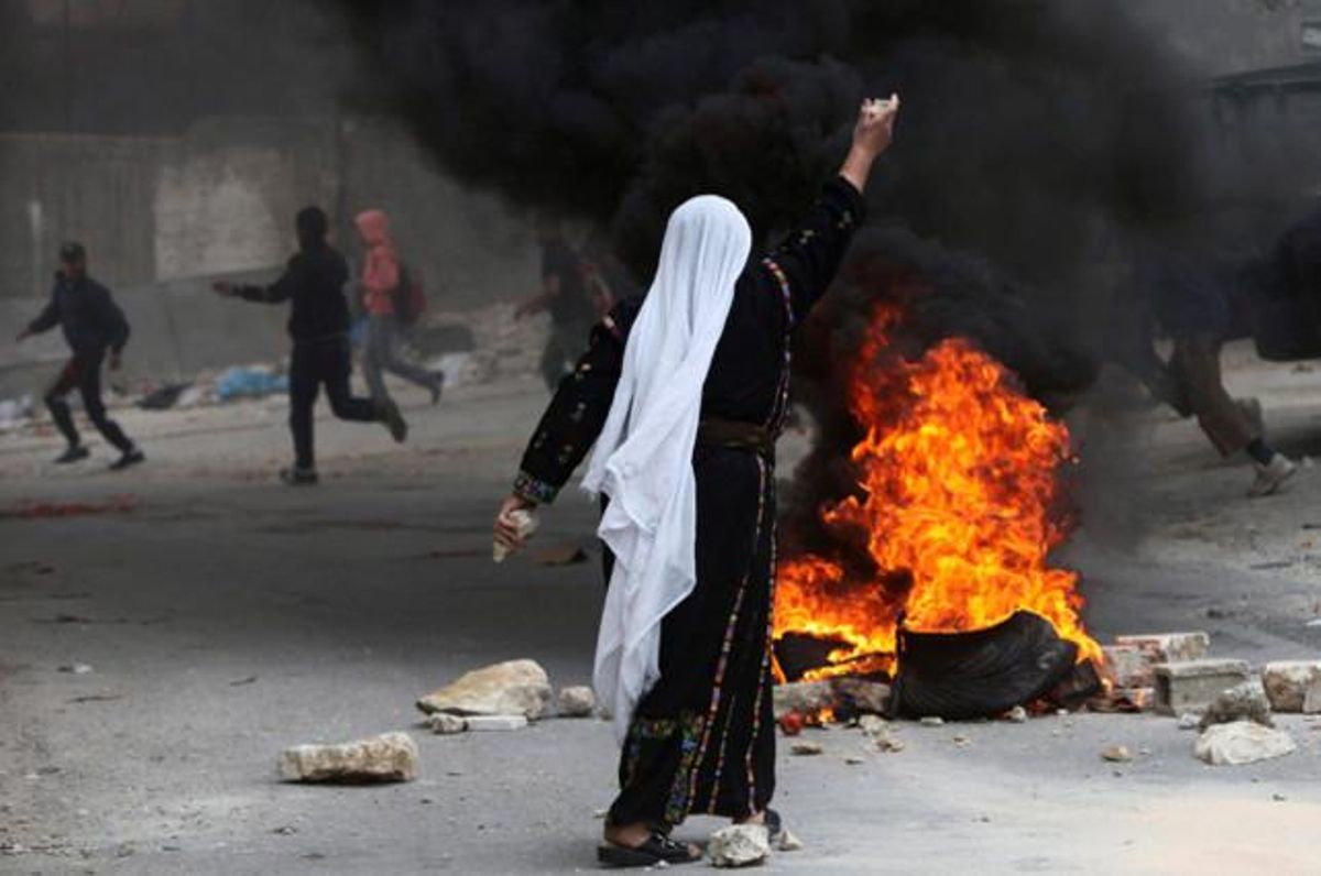 Una dona es disposa a llançar una pedra durant un enfrontament entre tropes israelianes i palestins, a la ciutat cisjordana d’Hebron.